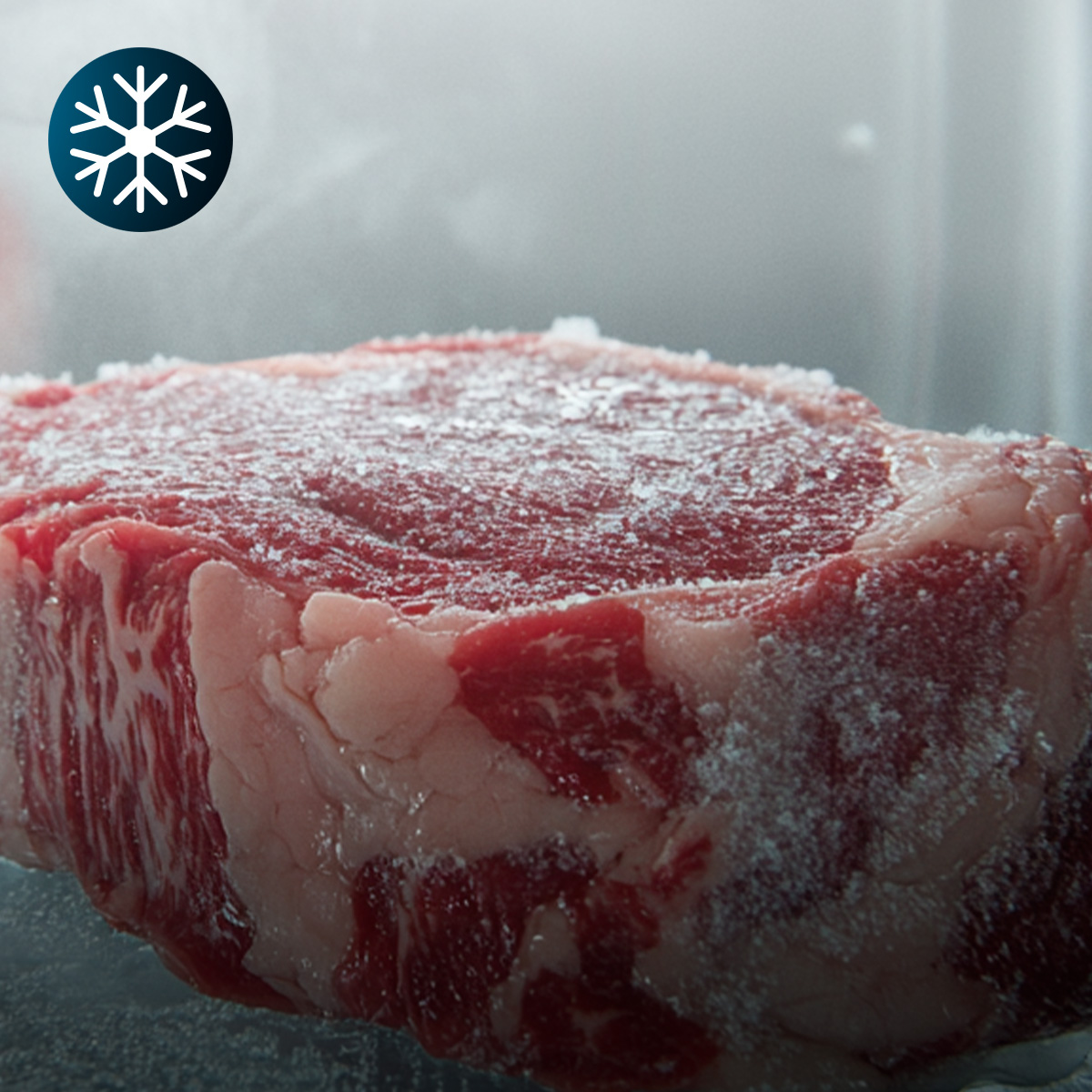 Una bistecca cruda e spessa coperta di brina, con un'icona di fiocco di neve blu in alto a sinistra.