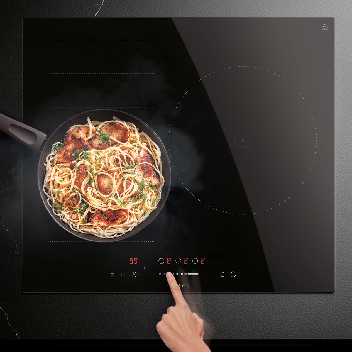 Un dedo opera el control táctil de una placa de inducción negra con una sartén con pasta.