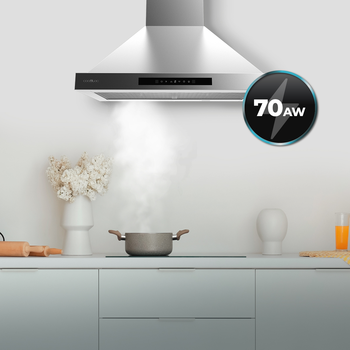 Una campana extractora de acero inoxidable sobre una olla con vapor en una cocina luminosa.