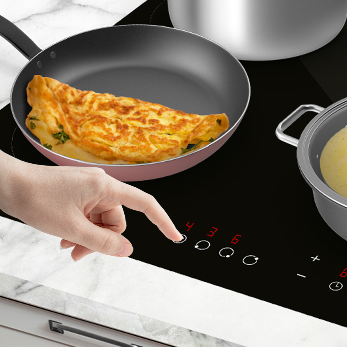 Mano operando la placa de inducción con sartén para tortilla.