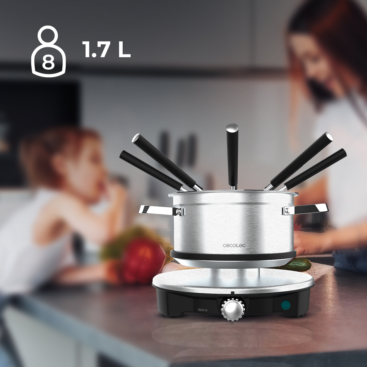 Set da fonduta argentato con sei forchette su un piano cucina, con una donna e un bambino sullo sfondo.