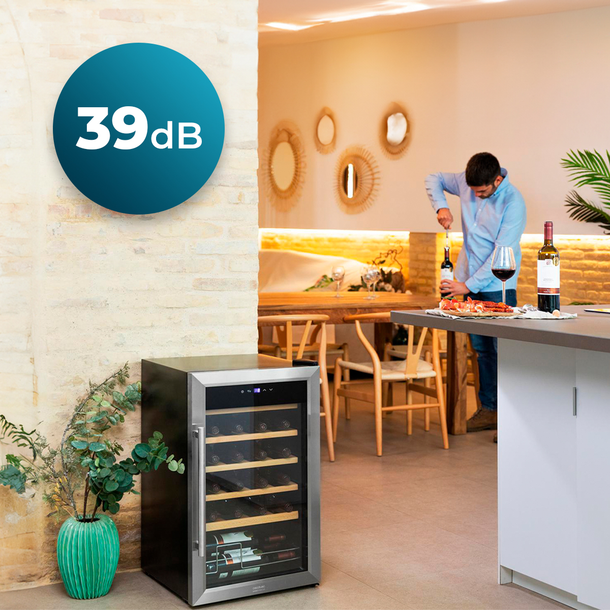 Una cantinetta per vino si trova in cucina. Un uomo sullo sfondo apre una bottiglia di vino. È visibile un'icona da 39dB.