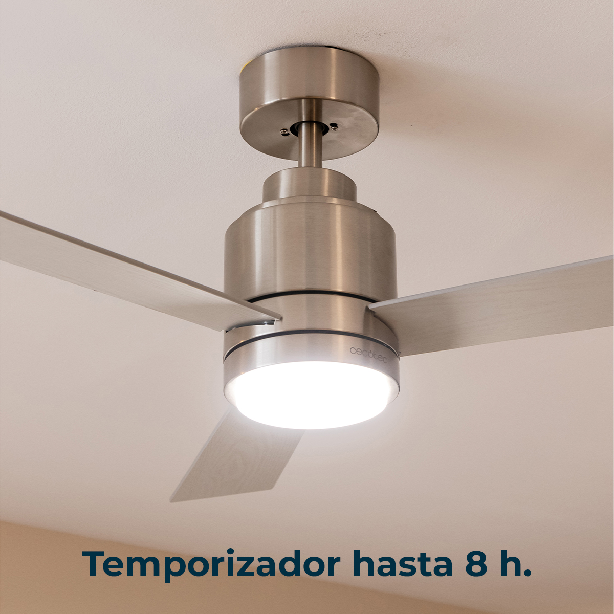 Moderno ventilatore da soffitto in metallo con luce LED integrata montato su un soffitto bianco.
