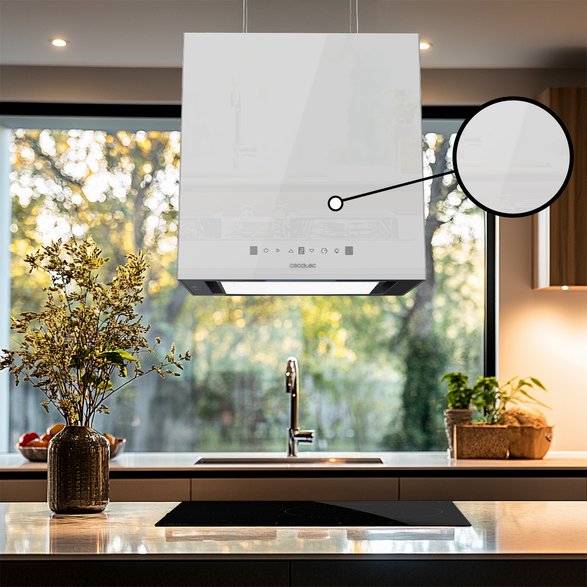 Moderna campana extractora blanca sobre una isla de cocina con placa de inducción y vista exterior.