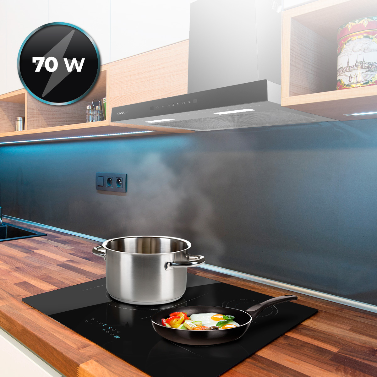 Una olla de acero inoxidable y una sartén con huevos y verduras se cocinan en una placa de inducción.