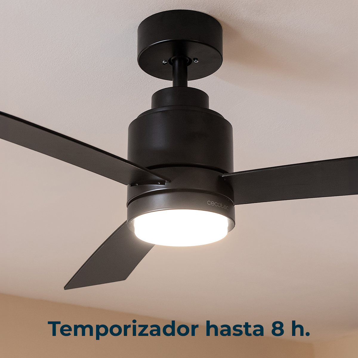 Un ventilatore da soffitto nero con una luce illuminata è montato su un soffitto bianco.