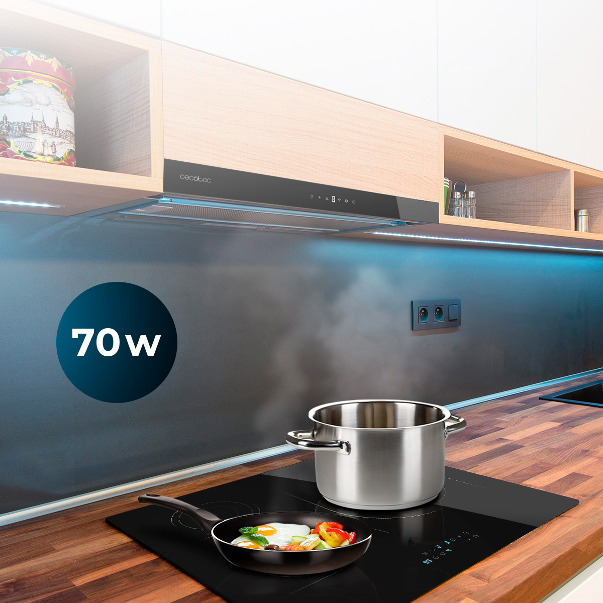 Olla de acero inoxidable y sartén con huevo frito en placa de inducción negra en cocina moderna con extractor.