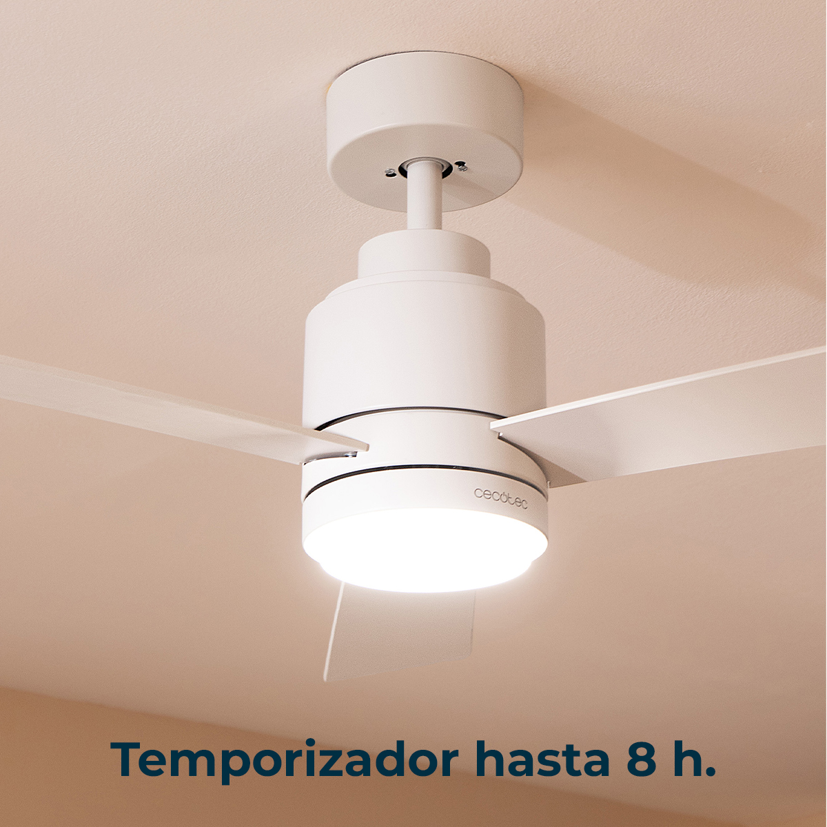 Un ventilatore da soffitto bianco con una lampada illuminata su un soffitto beige.