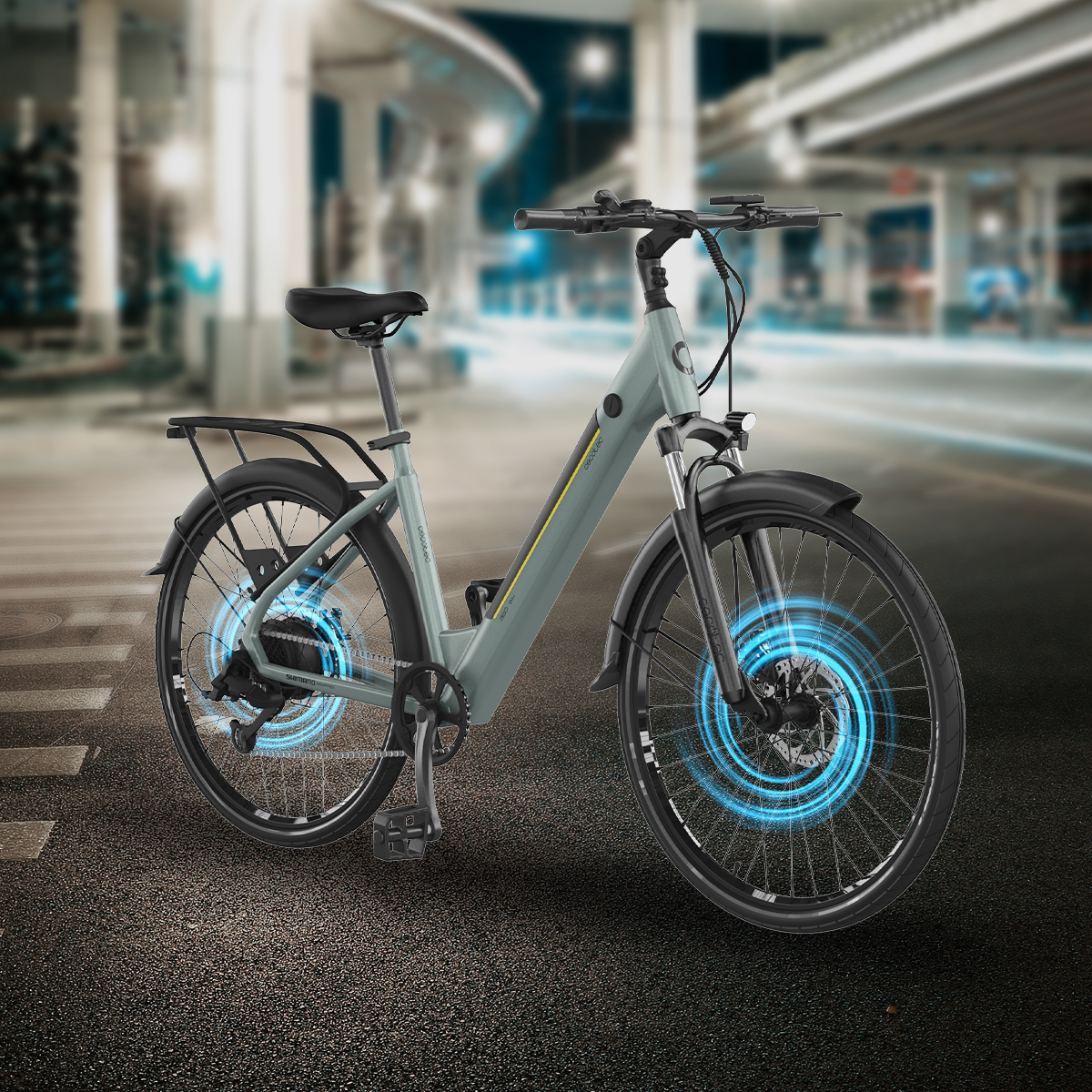 Una bicicleta eléctrica gris en la calle con efectos azules en las ruedas ante una ciudad borrosa de noche.