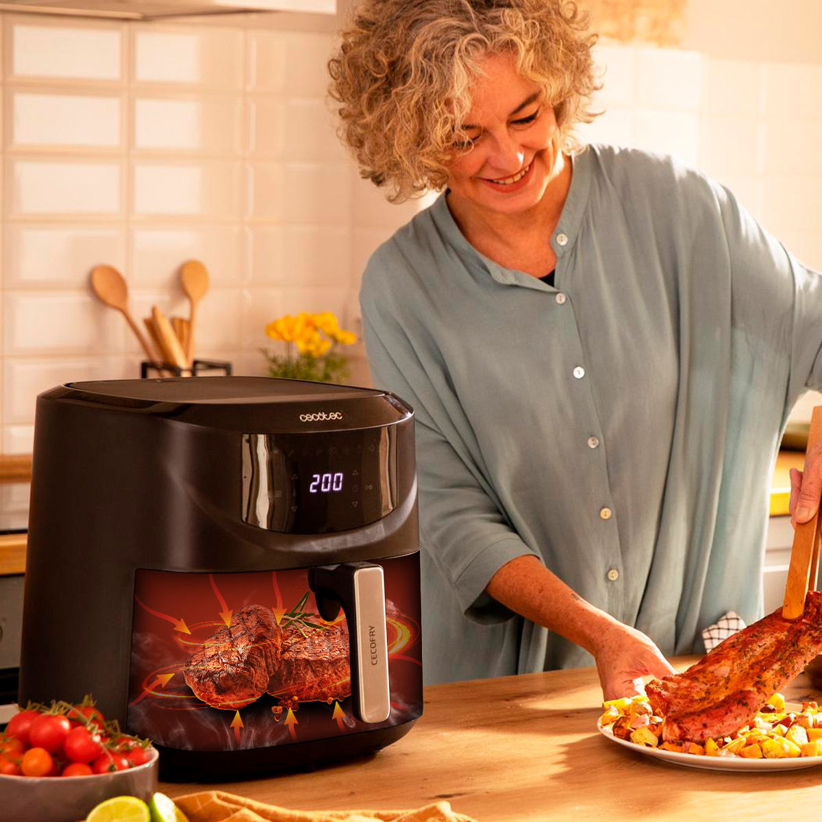 Una donna serve carne con le pinze accanto a una friggitrice ad aria con display.