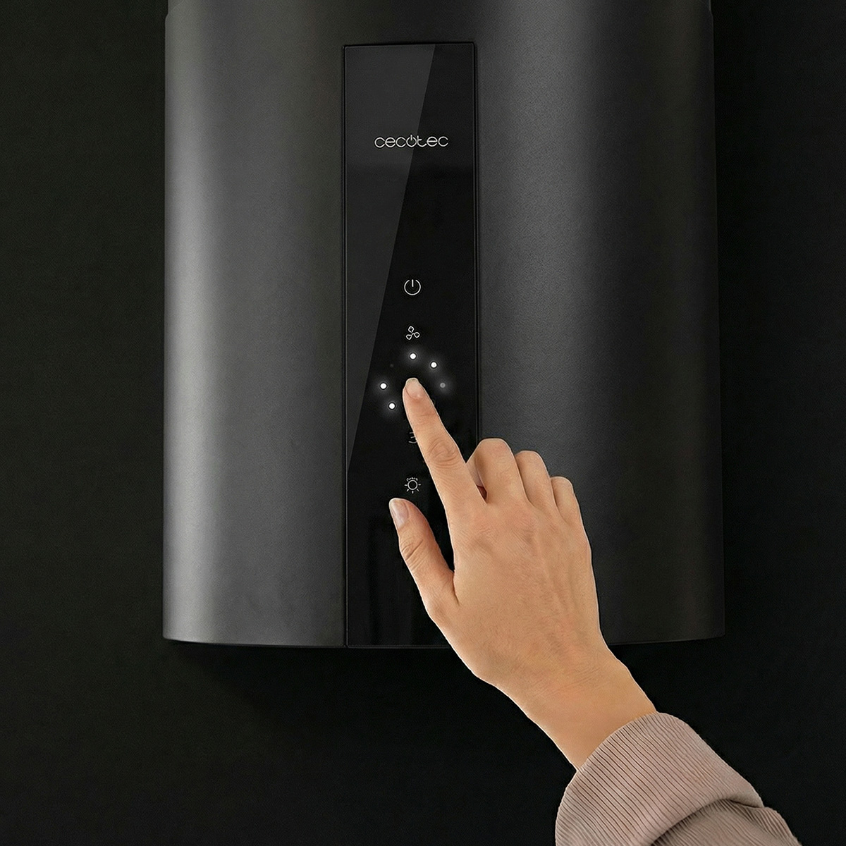 Mano interactúa con un panel de control negro Cecotec con botones iluminados.