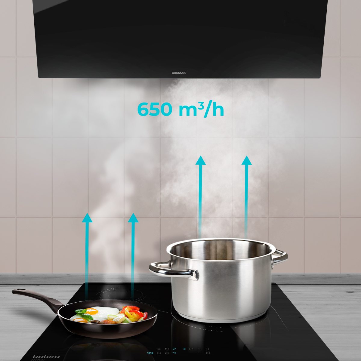 Campana extractora sobre placa de inducción con olla y sartén, vapor ascendente y flechas azules con texto 650 m3/h.