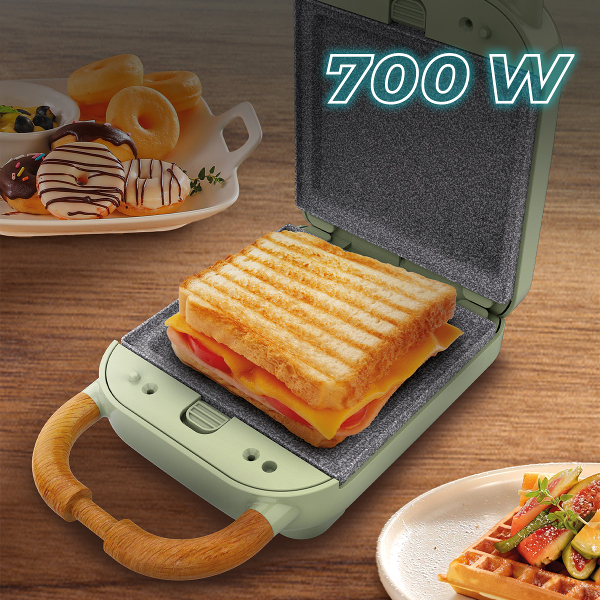 Una piastra per panini verde da 700W su legno, con un toast grigliato, ciambelle e waffle.