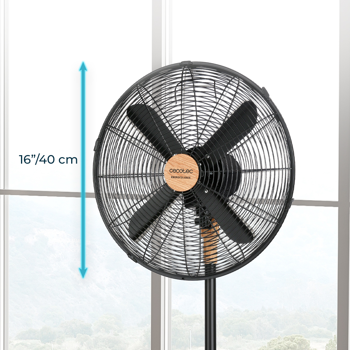 Ventilador de pie negro con centro de madera y 40 cm de diámetro frente a una ventana luminosa.