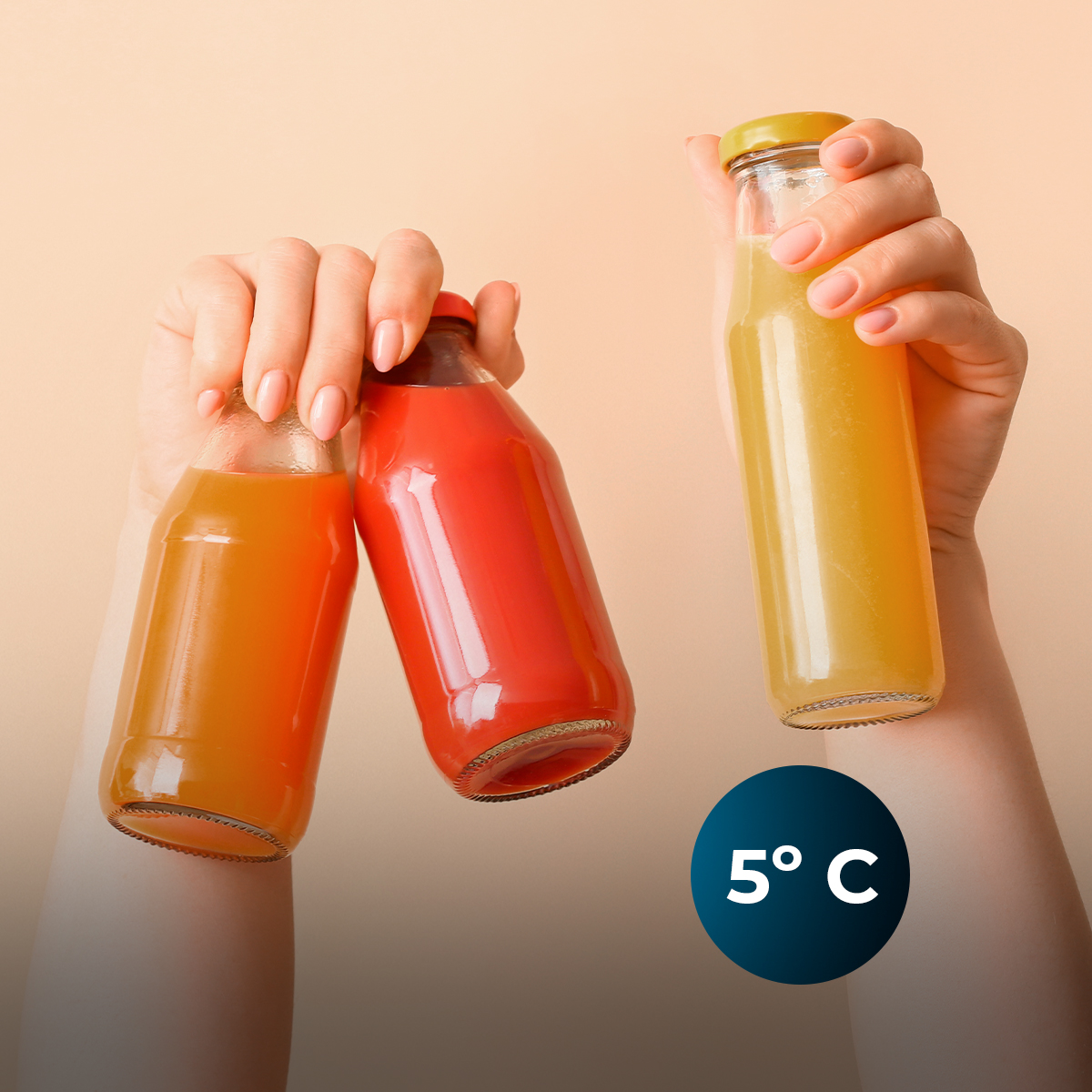 Manos sosteniendo tres botellas de vidrio con jugo de colores sobre fondo beige, con un icono de 5 grados Celsius.