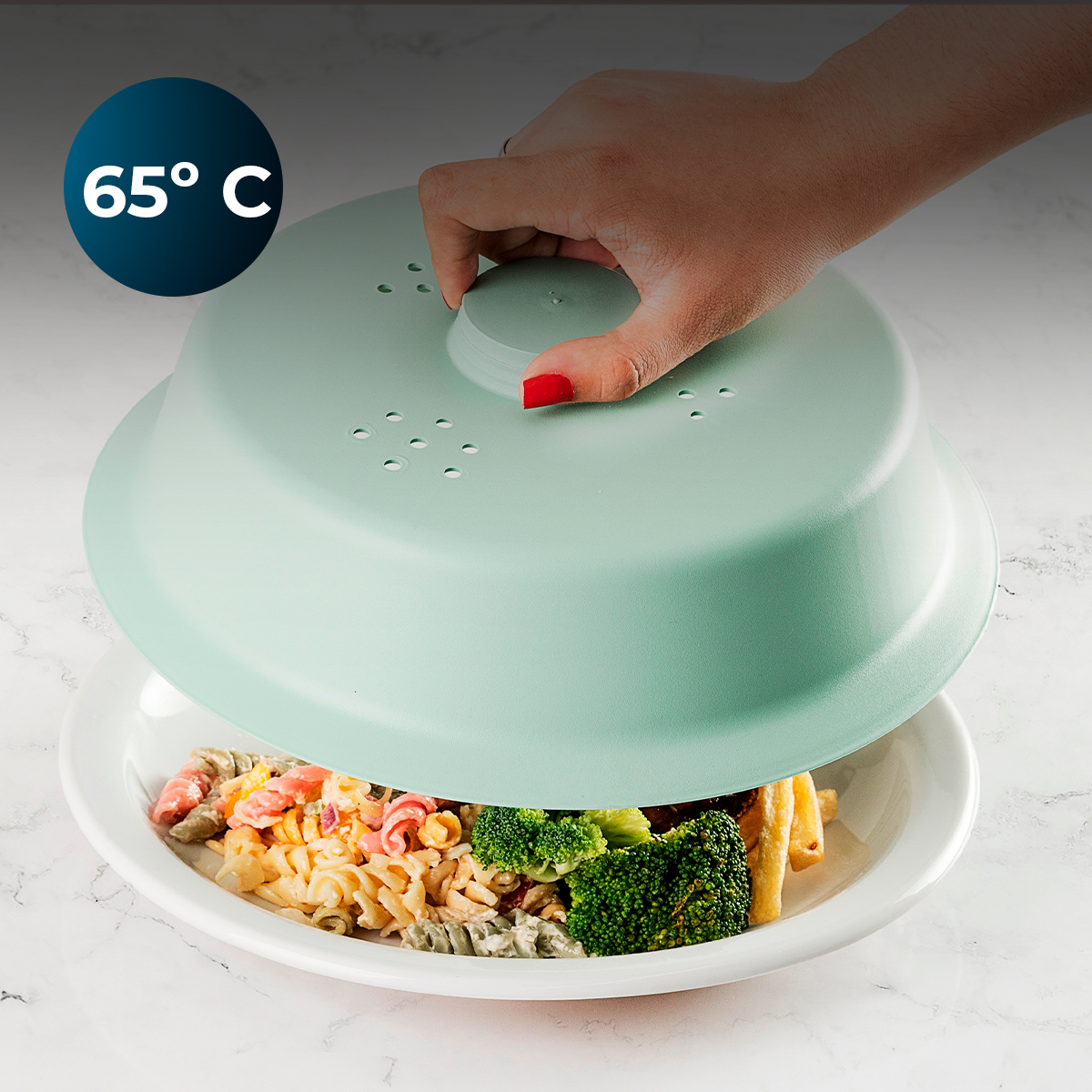 Una mano levanta una tapa verde menta de un plato de pasta y brócoli.