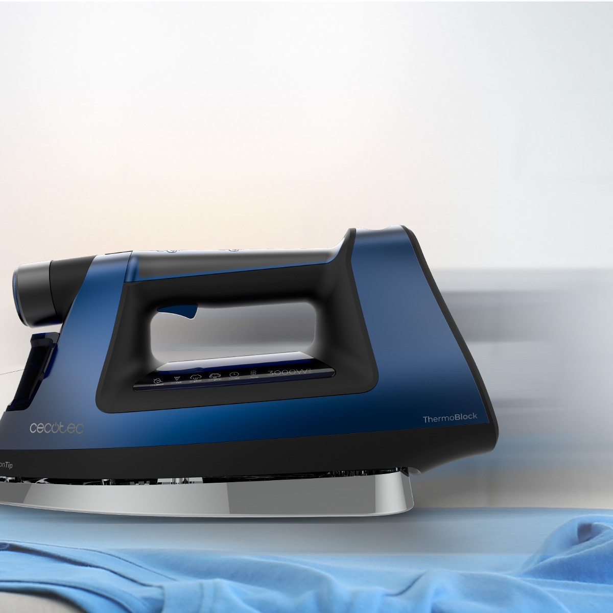 Ferro da stiro a vapore blu e nero su un indumento blu su un tavolo con sfondo bianco.