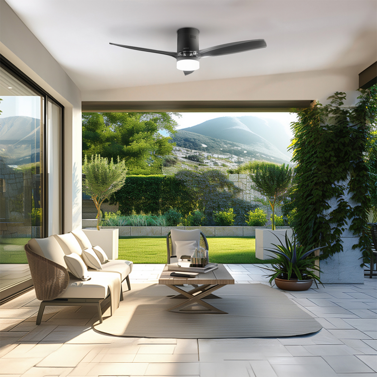Moderne Terrassenlounge mit Sofa, Tisch und Deckenventilator vor einer Berglandschaft.