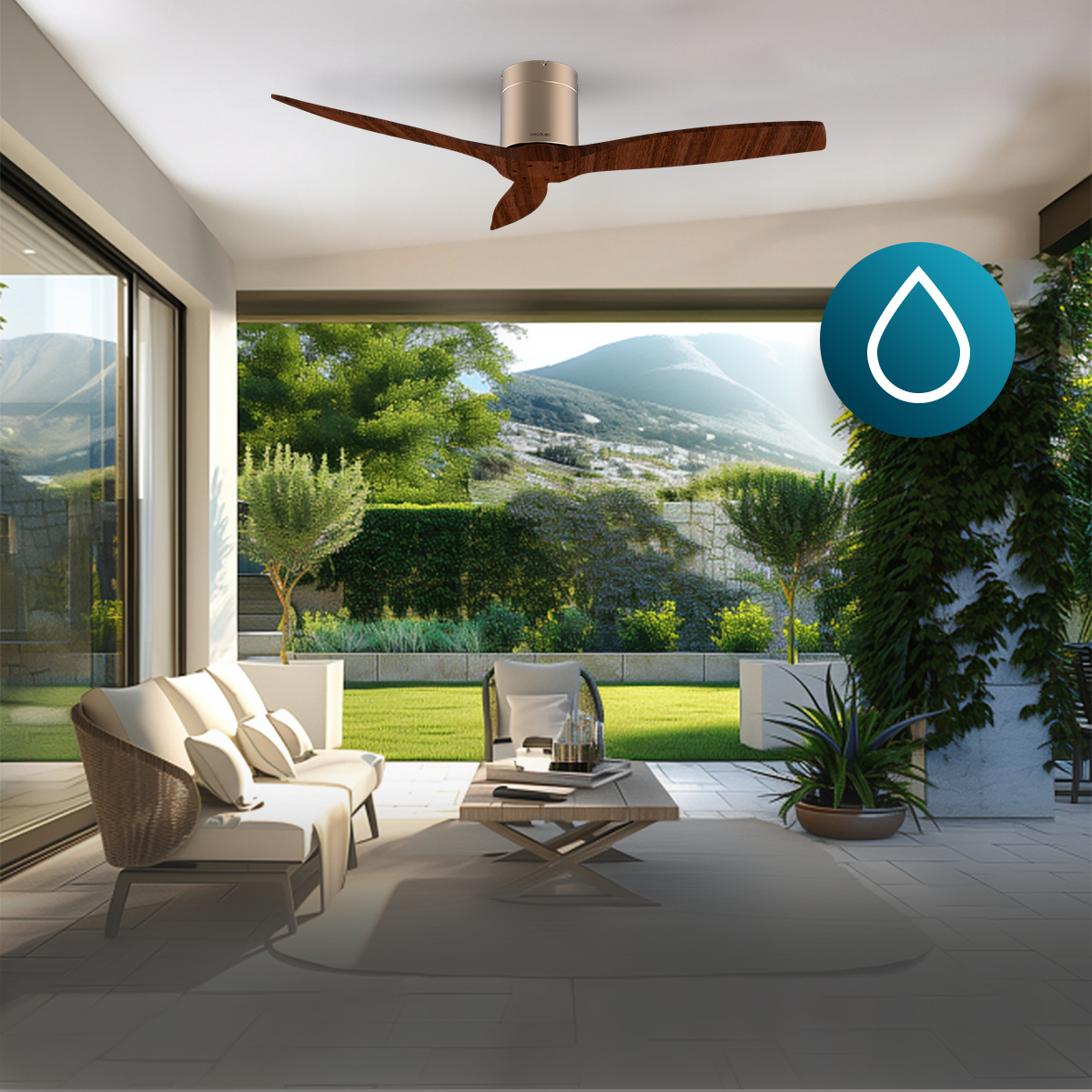 Patio moderno con ventilador de techo, sofá blanco, mesa y vistas panorámicas a la montaña.