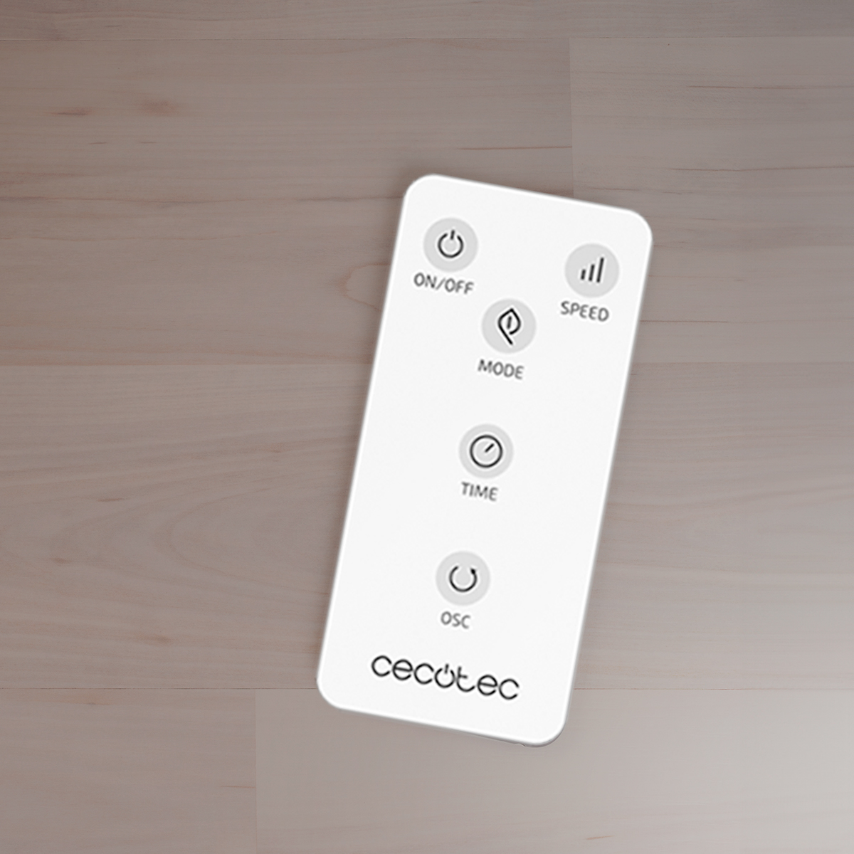 Un telecomando bianco Cecotec con pulsanti rotondi poggia su un pavimento in legno chiaro.