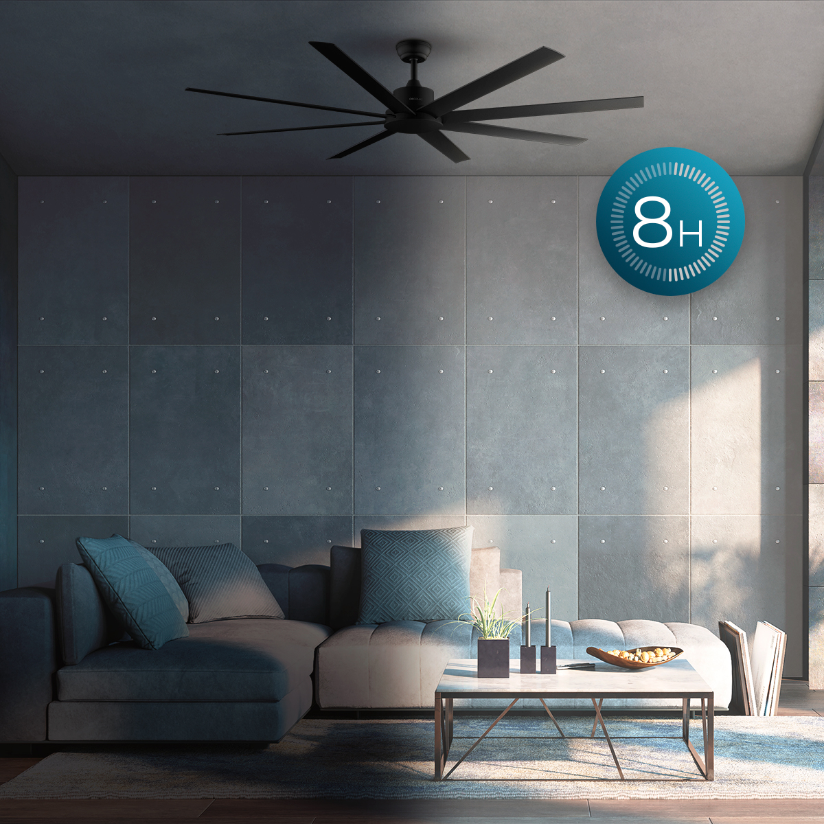 Salotto con ventilatore a soffitto, divano grigio, cuscini, tavolino e grafica blu 8H sulla parete.