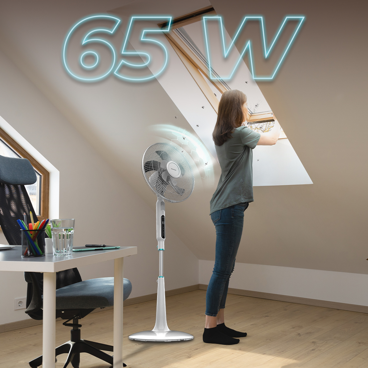 Una mujer abre una ventana de tejado en una habitación con escritorio y ventilador; '65 W' flota arriba.