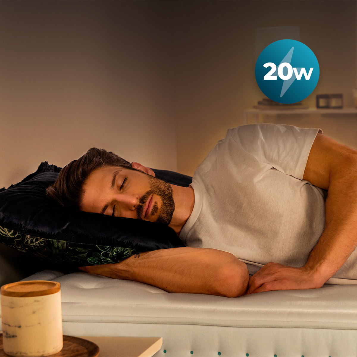 Un uomo dorme tranquillamente in un letto con cuscino blu, vicino a un comodino con un baratro. Icona 20W sullo sfondo.