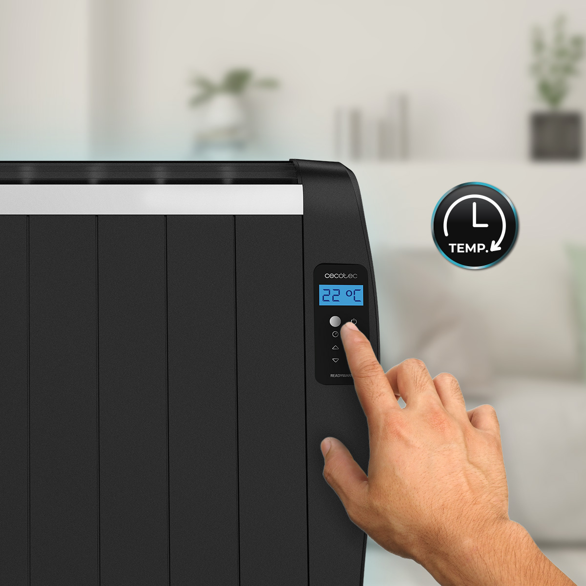 Una mano preme il pannello di controllo digitale di un termosifone elettrico nero che mostra 22 gradi Celsius.