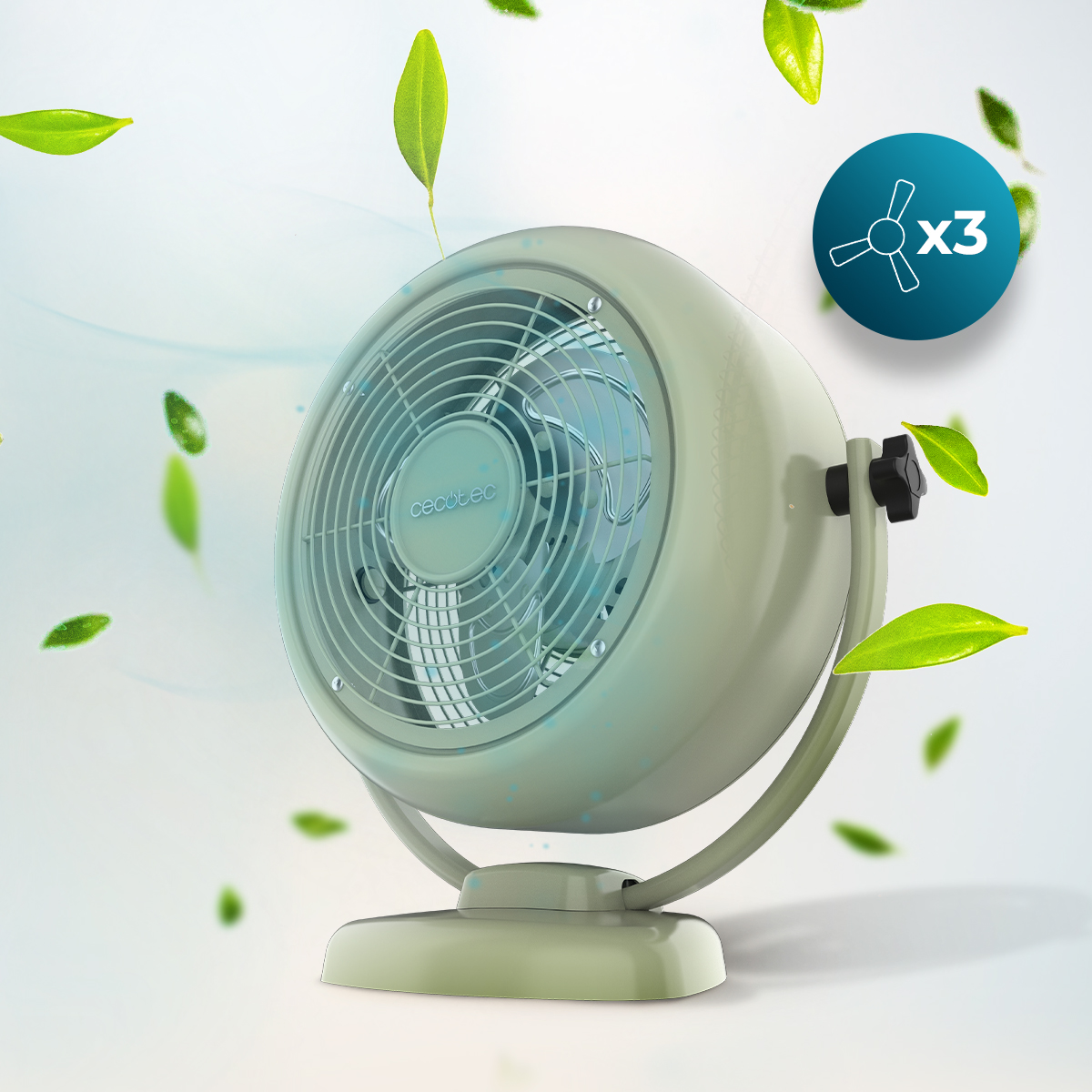 Un ventilatore da tavolo verde chiaro con griglia protettiva e tre pale, circondato da foglie verdi fluttuanti su fondo chiaro.
