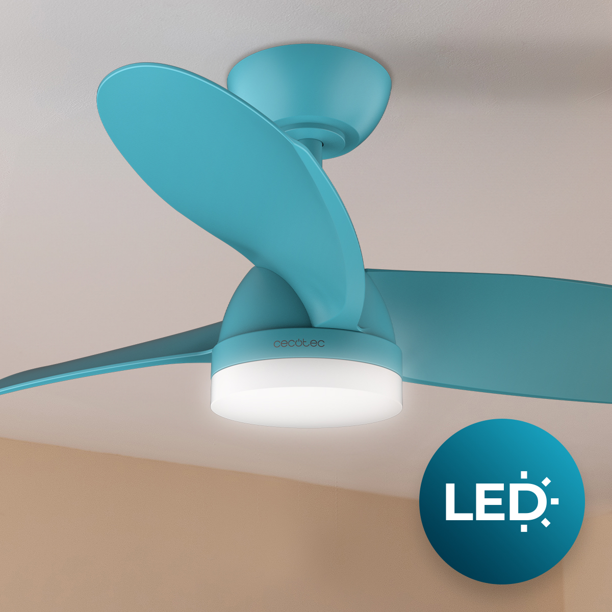 Un ventilador de techo turquesa con luz LED integrada está montado en un techo claro.