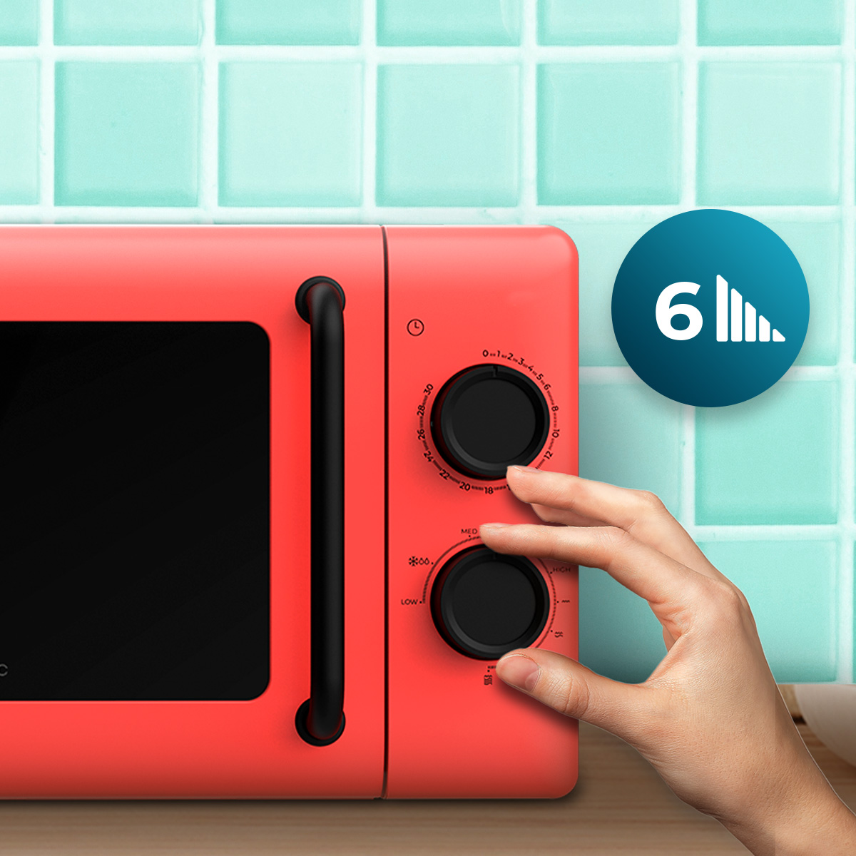 Mano ajustando una perilla en un microondas retro rojo contra azulejos azules.