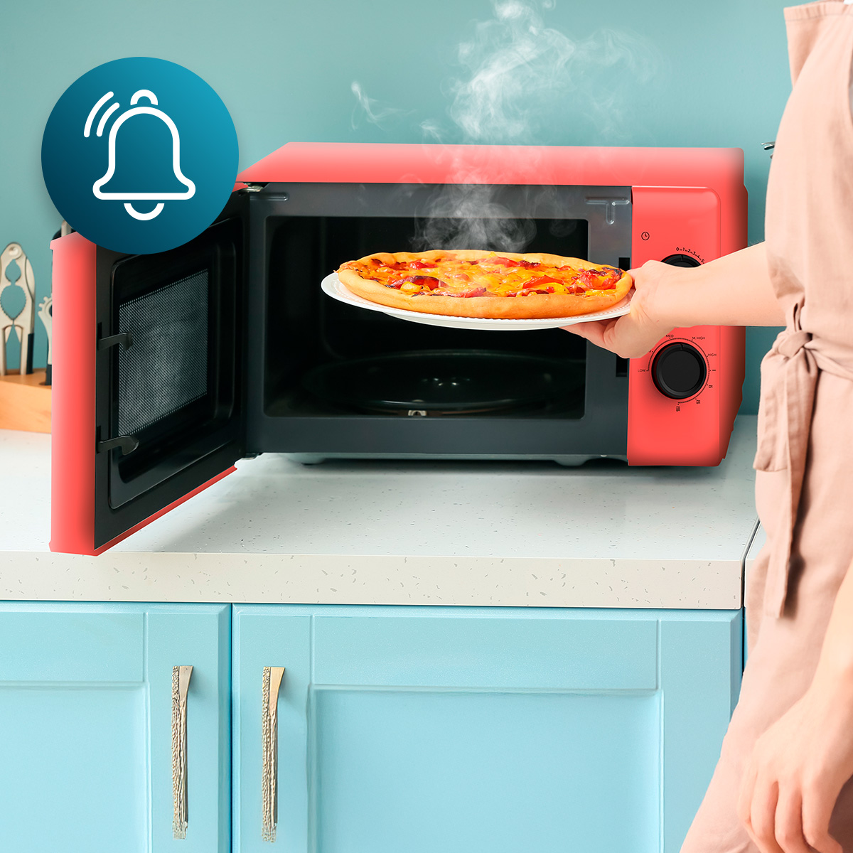 Una persona coloca una pizza caliente y humeante en un microondas rojo sobre un mostrador azul.