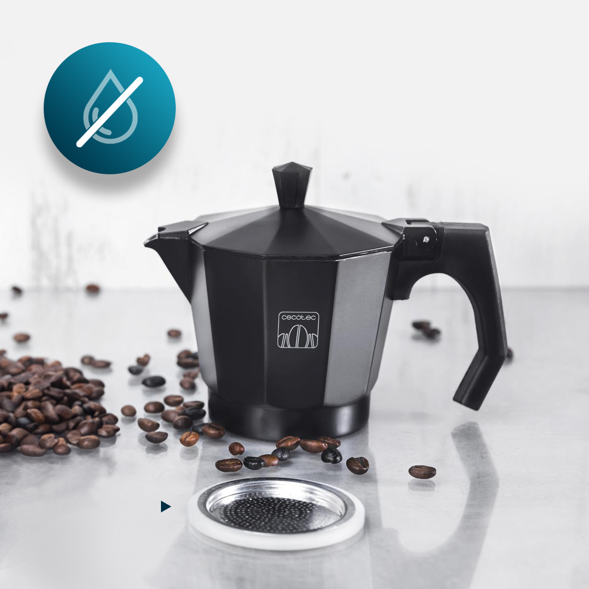 Una cafetera italiana negra sobre una superficie con granos de café dispersos y un filtro metálico.