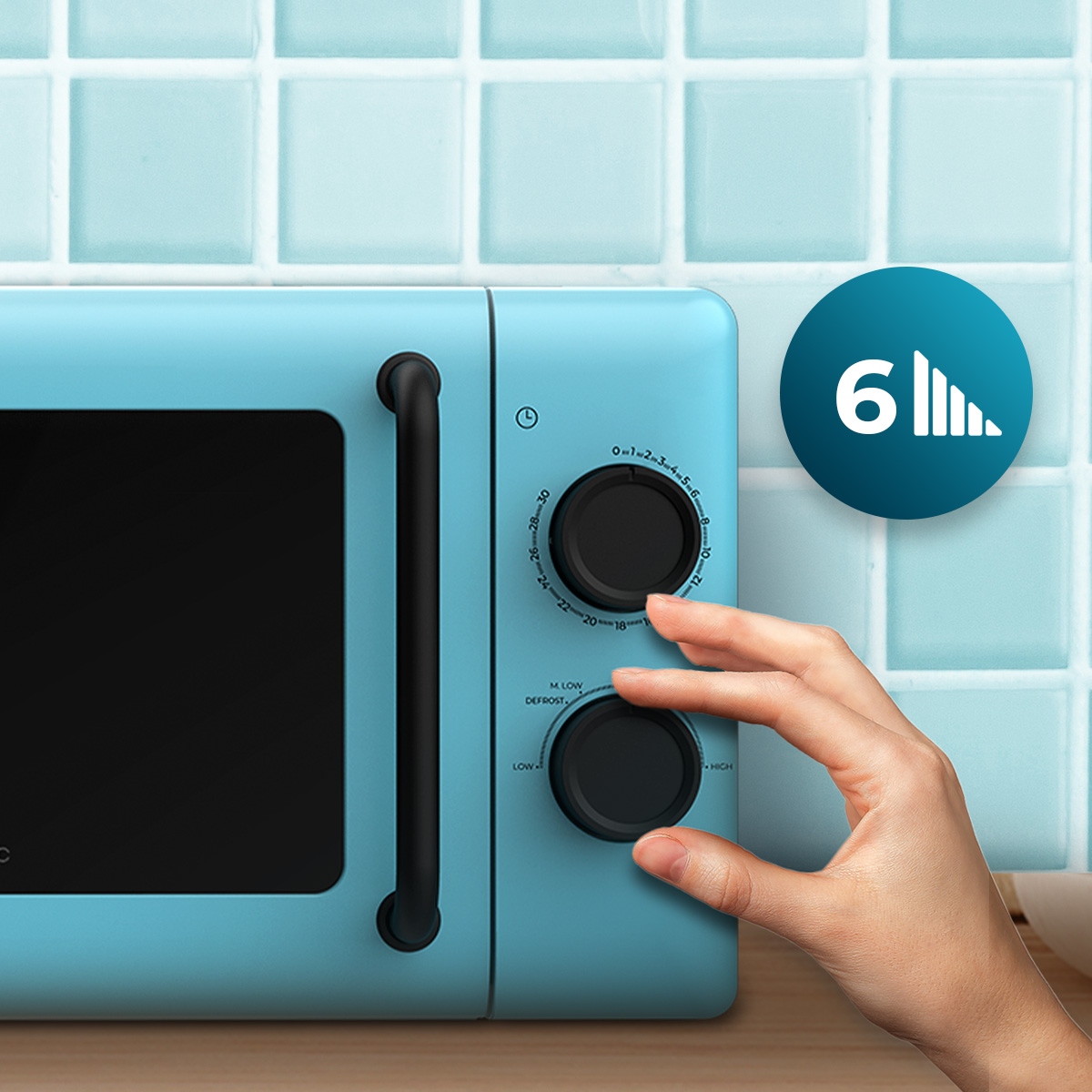 Una mano gira la perilla de un microondas azul claro frente a azulejos.