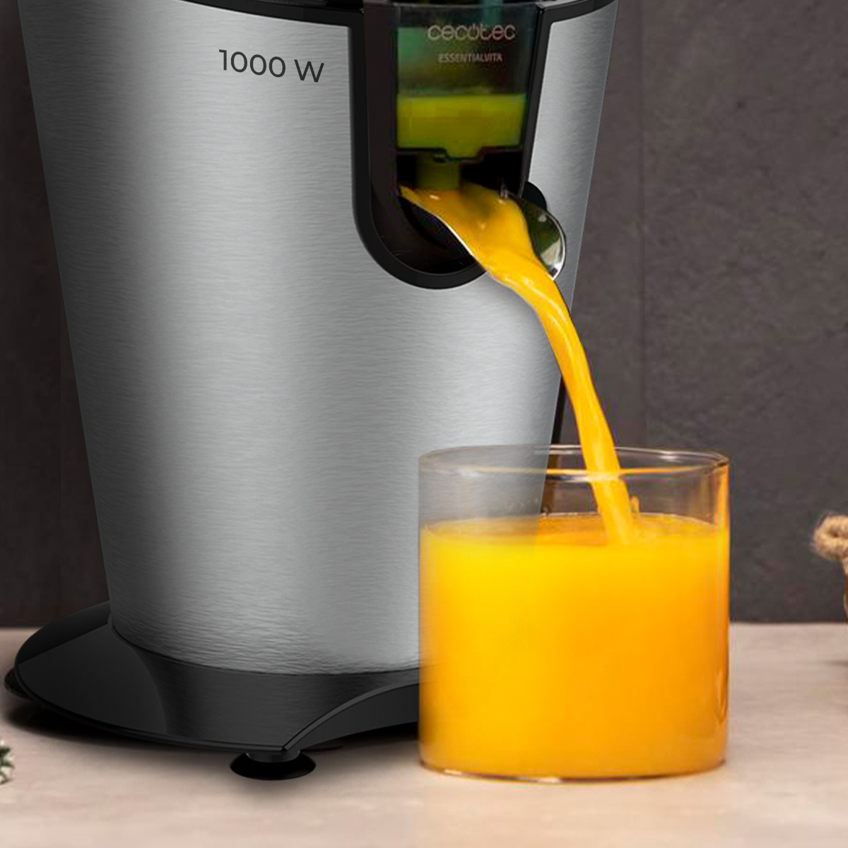 Un estrattore d'argento da 1000 W versa succo d'arancia fresco in un bicchiere.