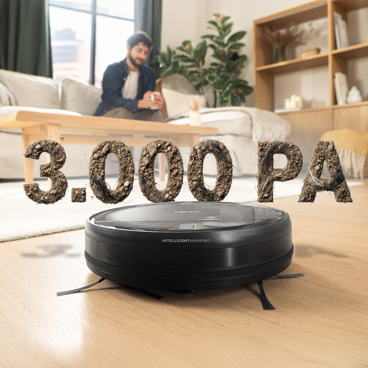 Un robot aspirapolvere nero su pavimento in legno con la scritta 3.000 PA fatta di terra e peli; sfondo di un soggiorno.