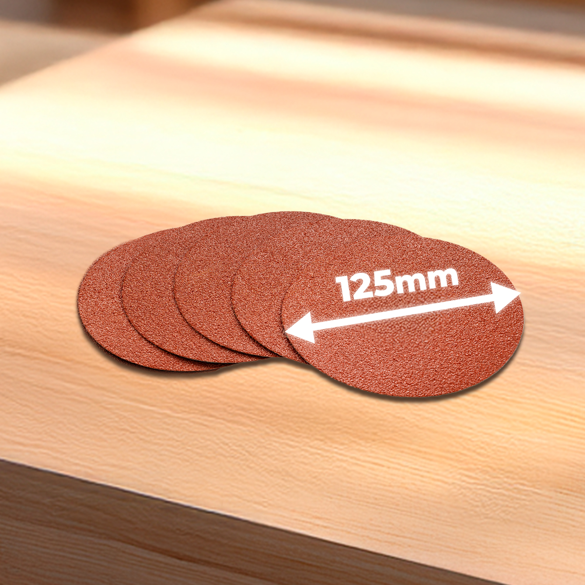 Varios discos de lija de color marrón rojizo con un diámetro de 125 mm sobre una superficie de madera.