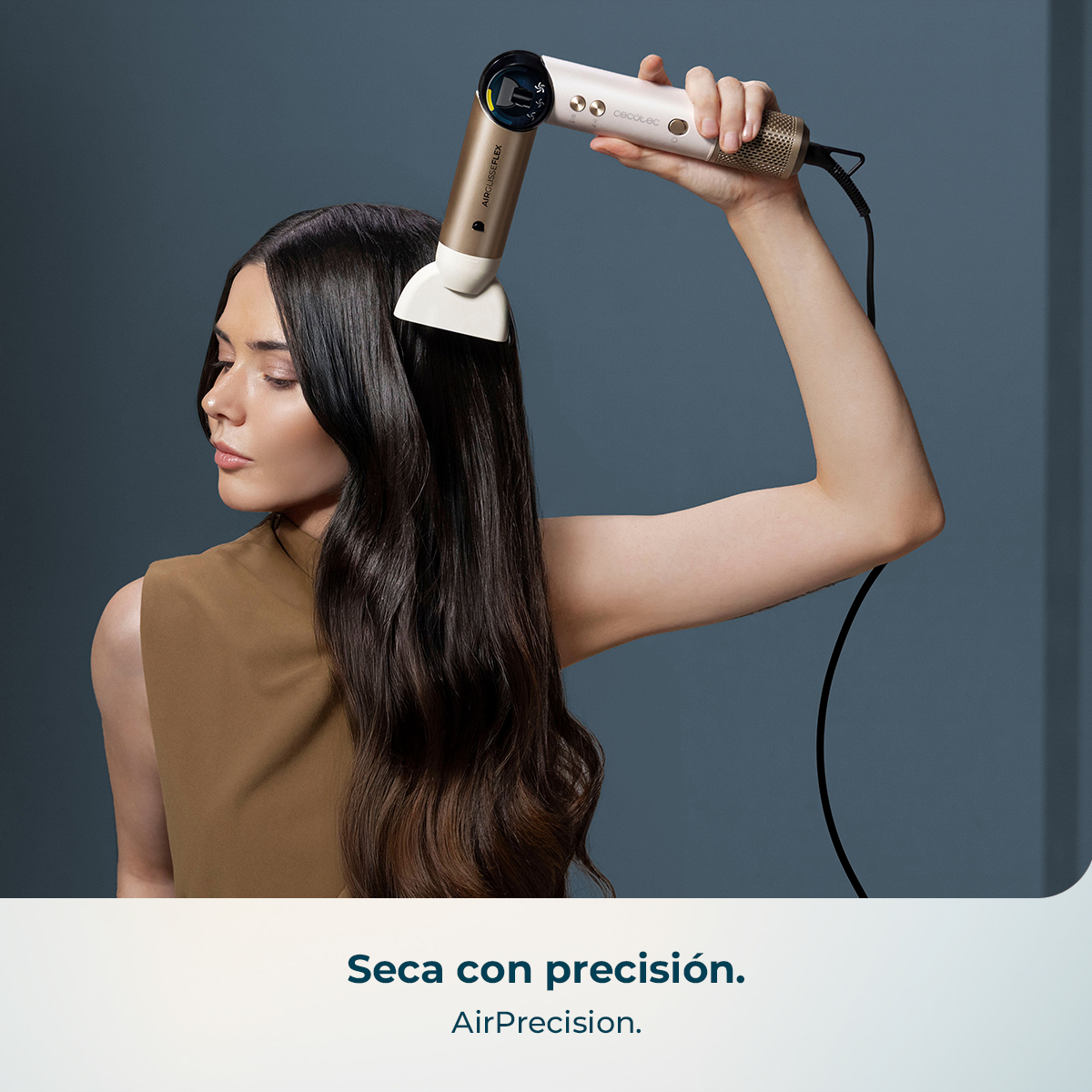 Mujer secando su pelo largo y oscuro con un secador moderno blanco y dorado.