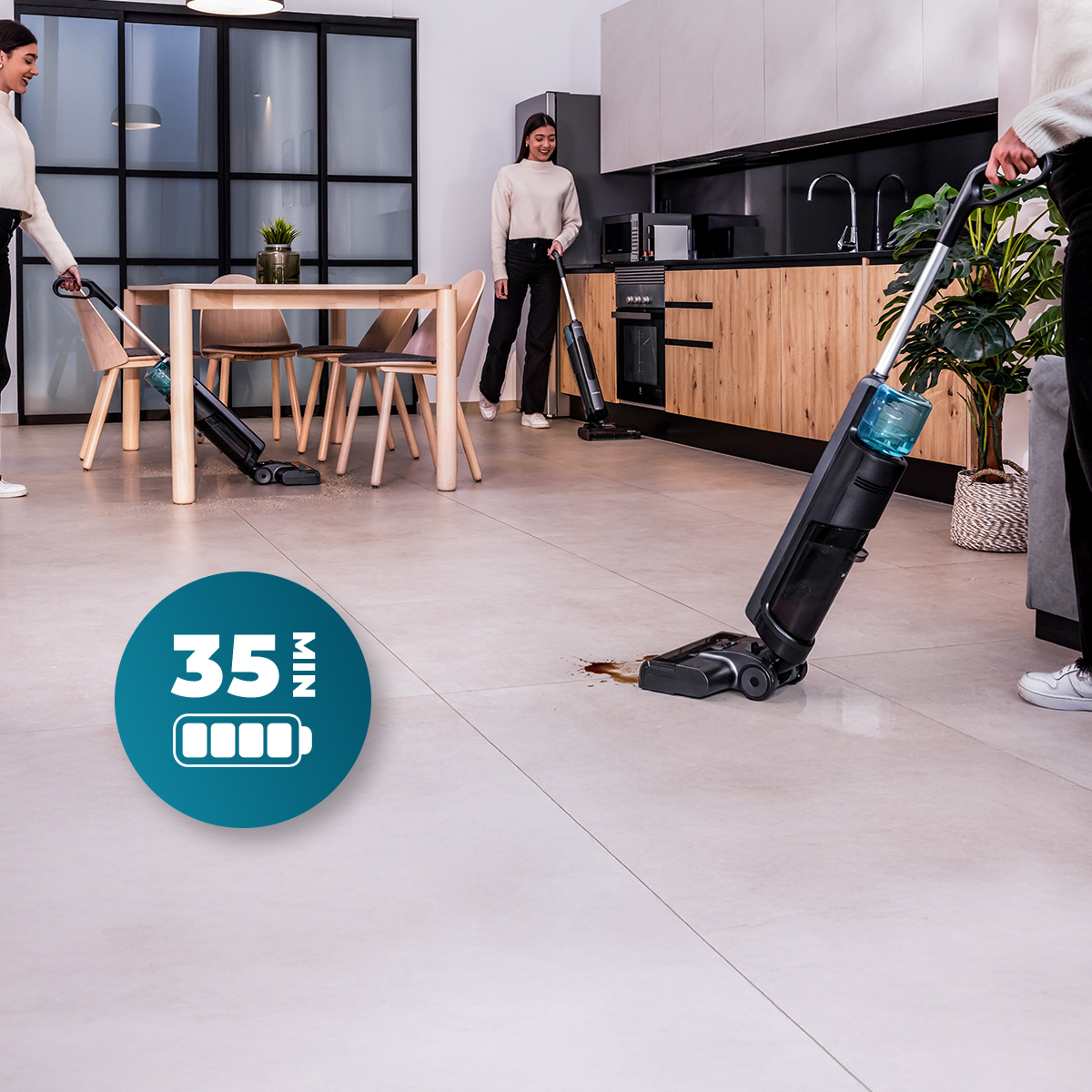 Tre donne usano scope elettriche senza fili in cucina con un'icona blu della batteria da 35 minuti.