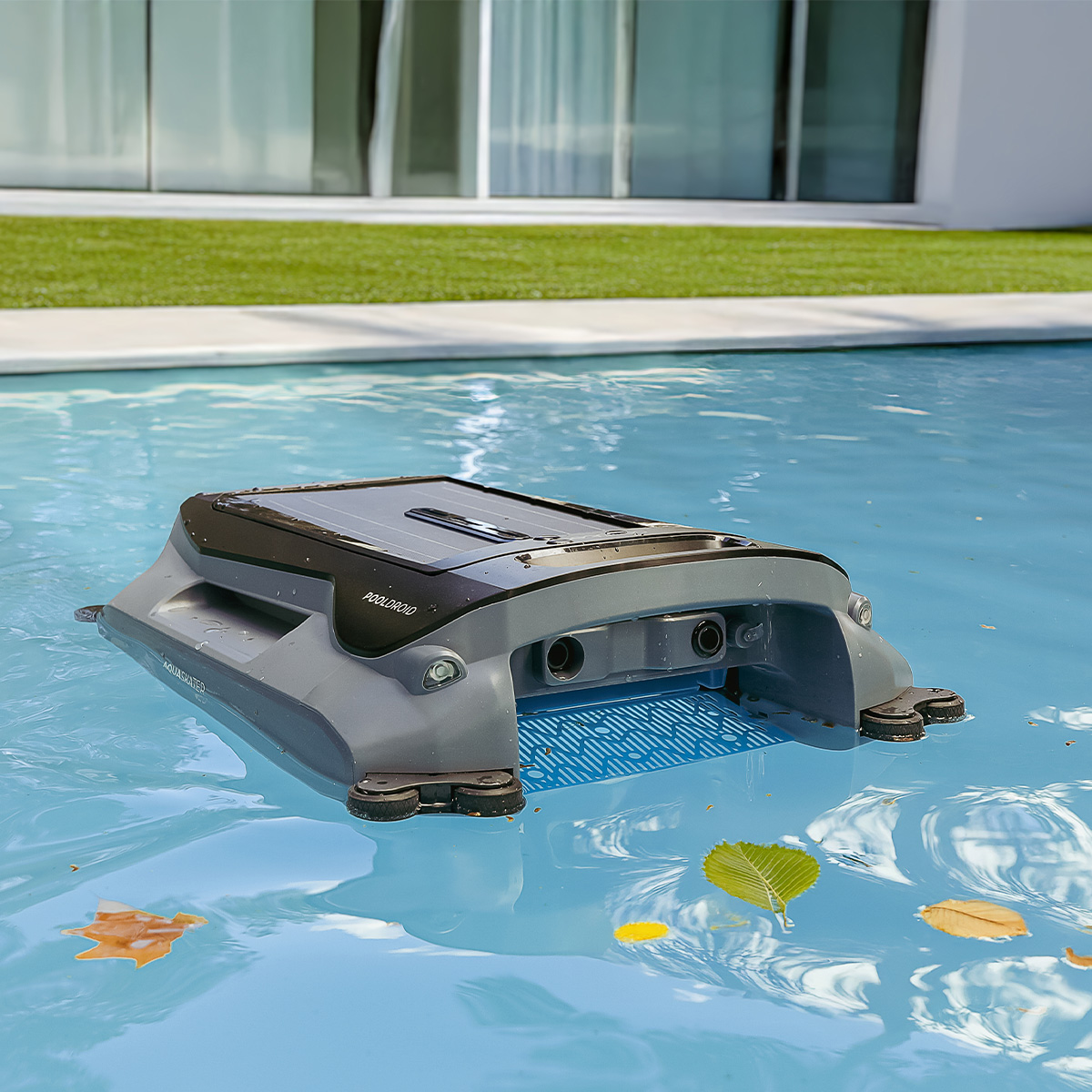 Un robot pulitore per piscina grigio pulisce la superficie dell'acqua.