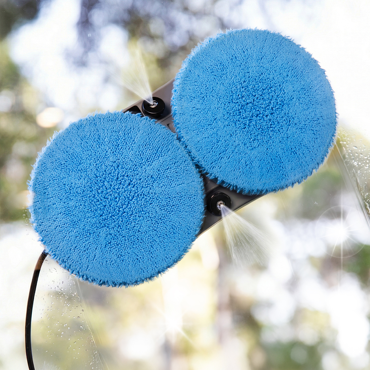 Un robot pulisci vetri automatico con due cuscinetti blu pulisce un vetro.