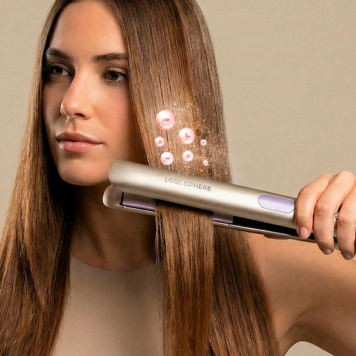 Una donna liscia i suoi lunghi capelli castani con una piastra per capelli dorata Lisse Isphere.