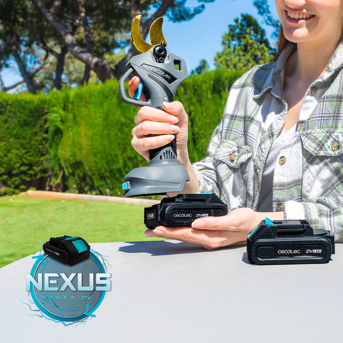 Una mujer sostiene una tijera de podar a batería, con baterías de repuesto y logo Nexus.
