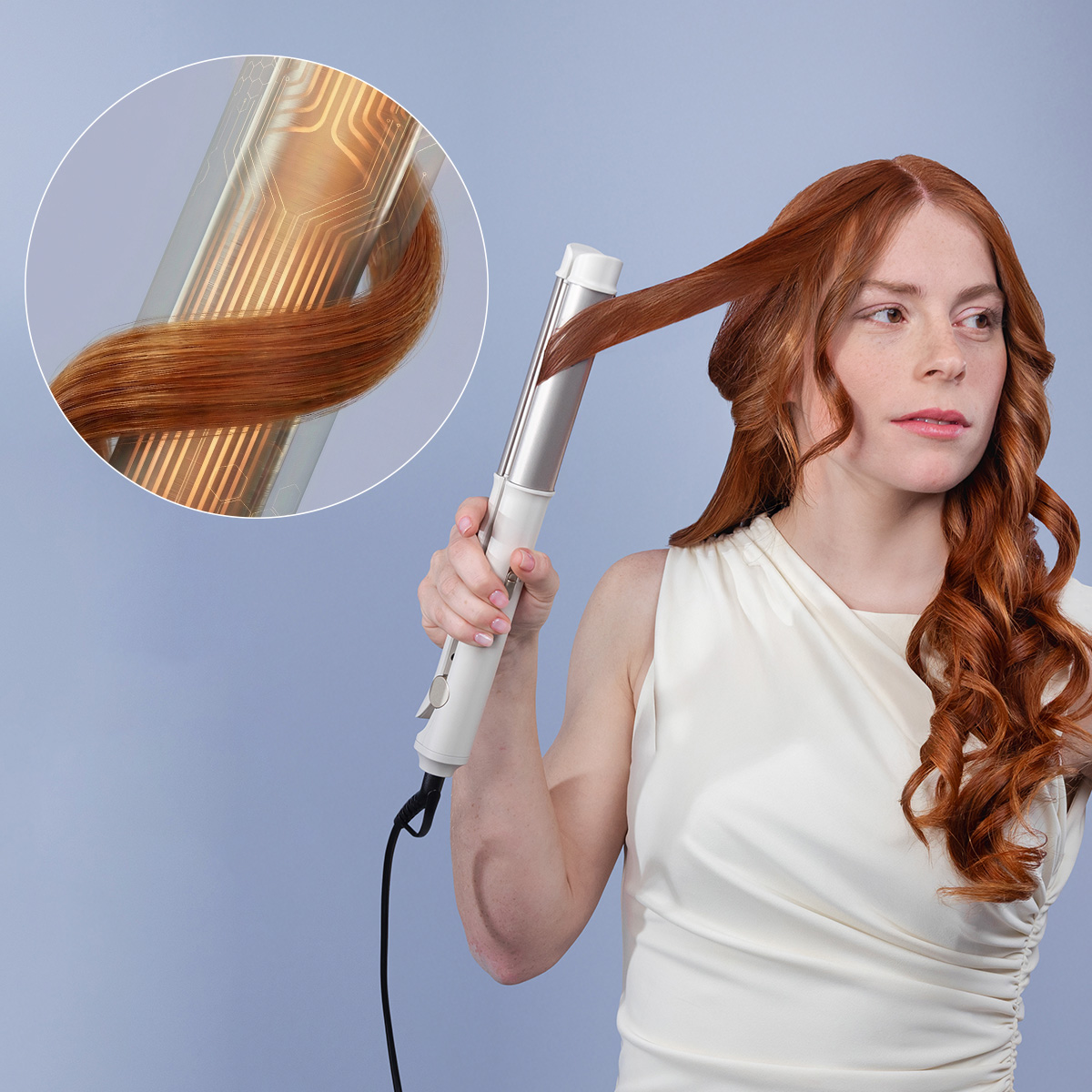 Una donna dai capelli rossi arriccia i capelli con un ferro, mostrando un dettaglio dell'elemento riscaldante e della ciocca.