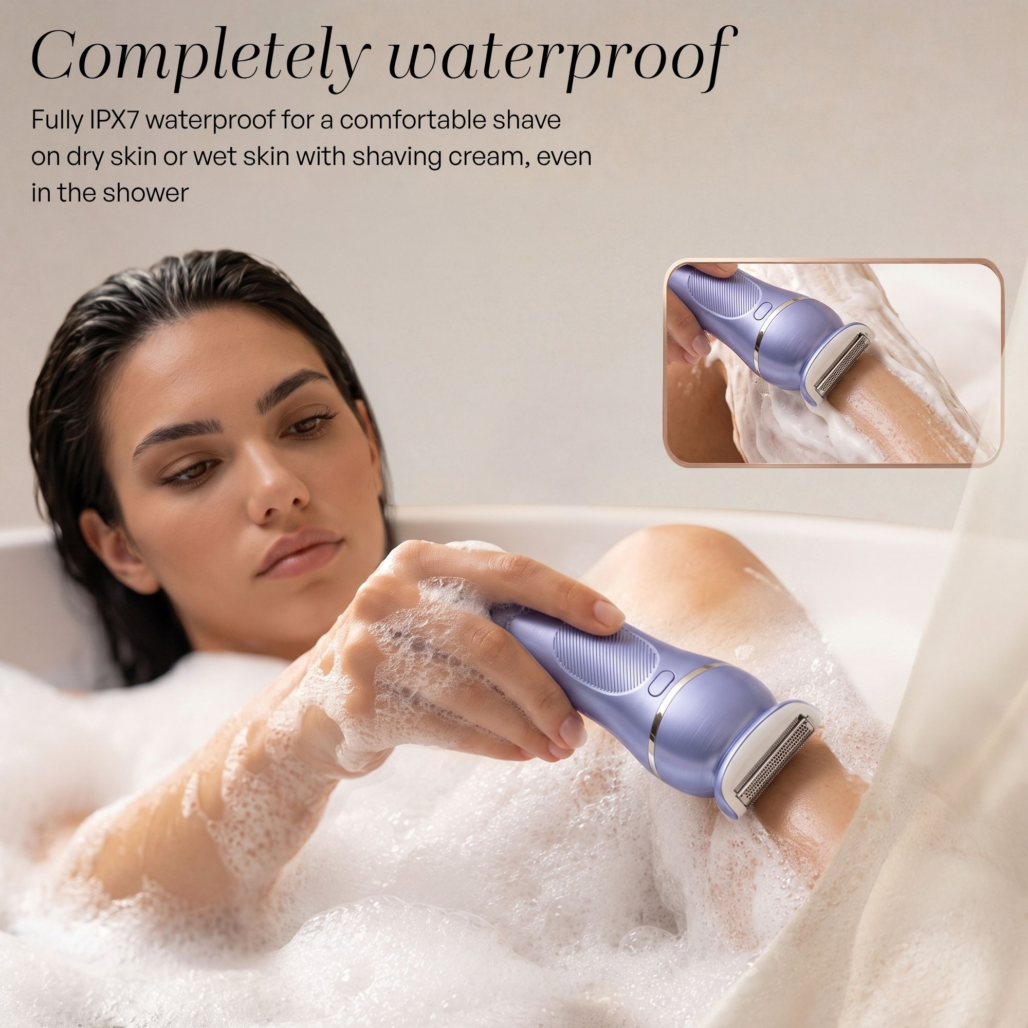 Une femme dans un bain moussant se rase la jambe avec un rasoir violet étanche.