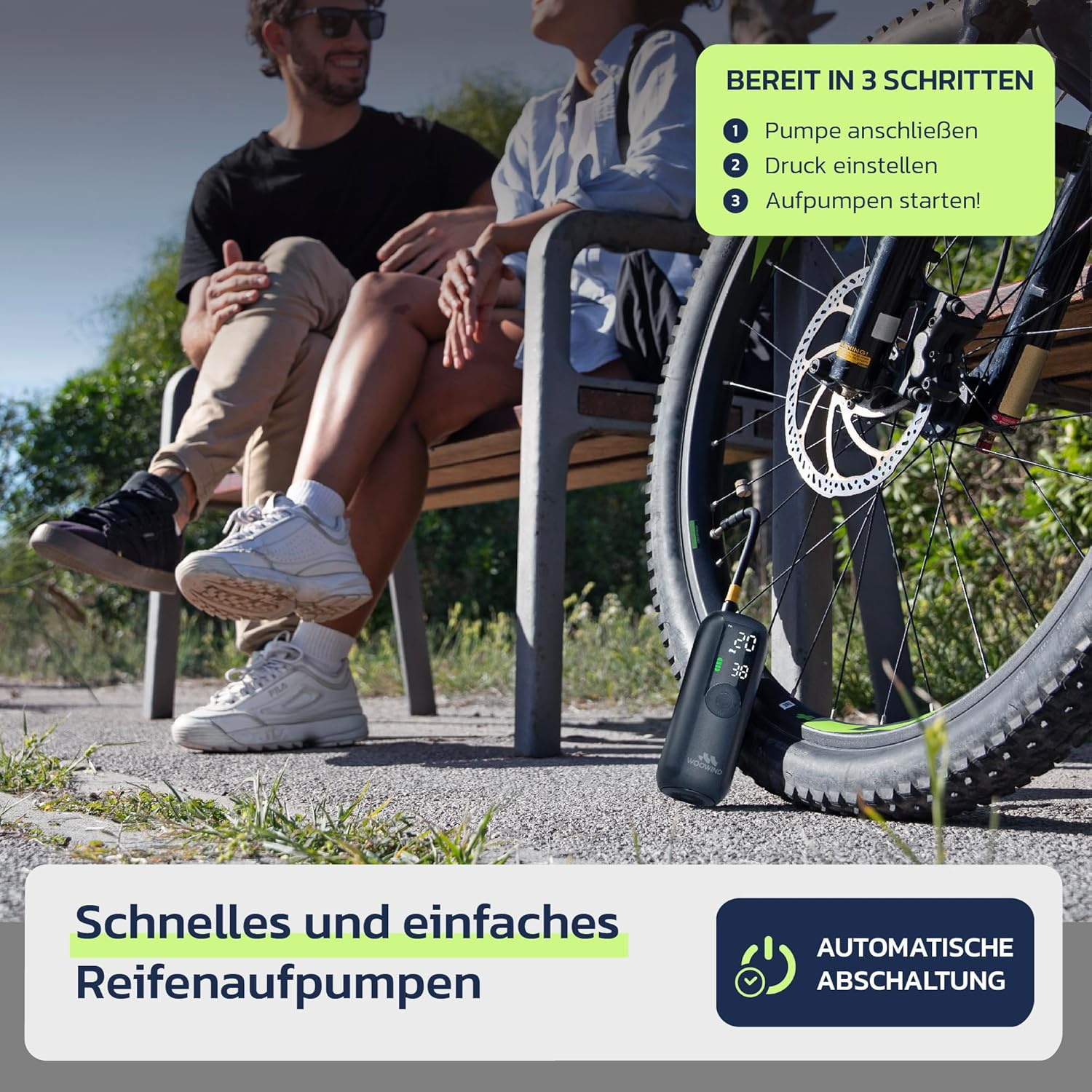 Pompe à pneu portable fixée à un pneu de vélo, avec un couple assis sur un banc de parc à l'arrière-plan.