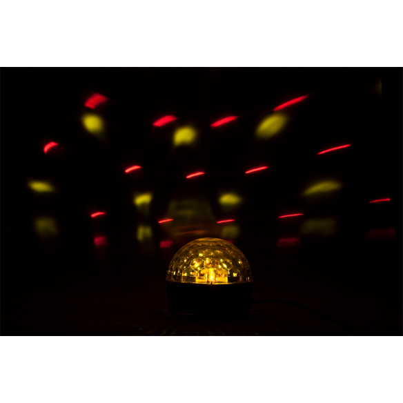 Eine leuchtende gelbe Diskokugel im Dunkeln wirft rote und gelbe Lichtstreifen an den Hintergrund.