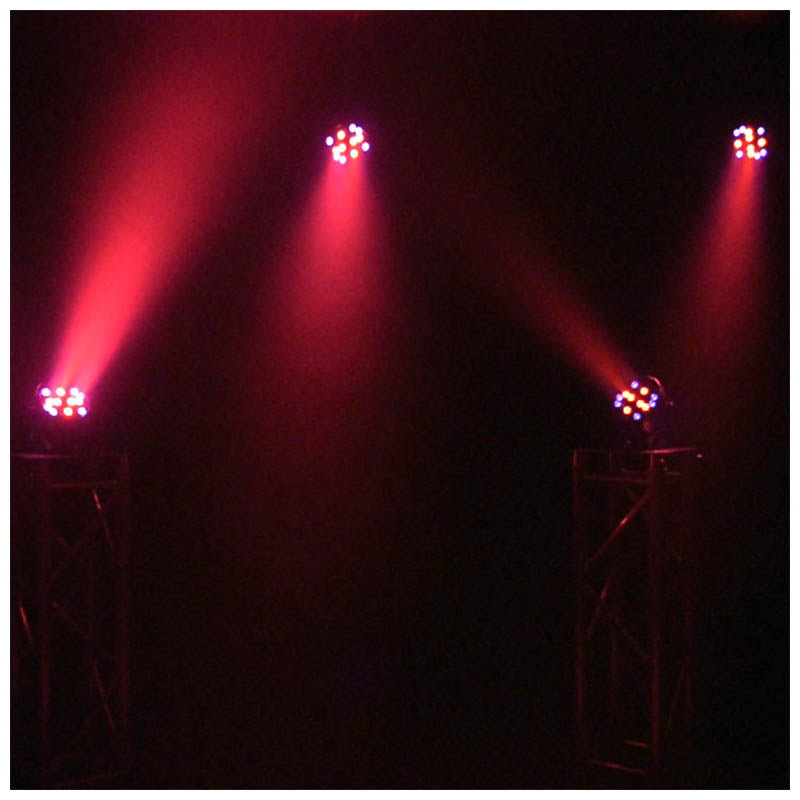 Bühnenbeleuchtung mit roten Lichtstrahlen auf Ständern vor dunklem Hintergrund.