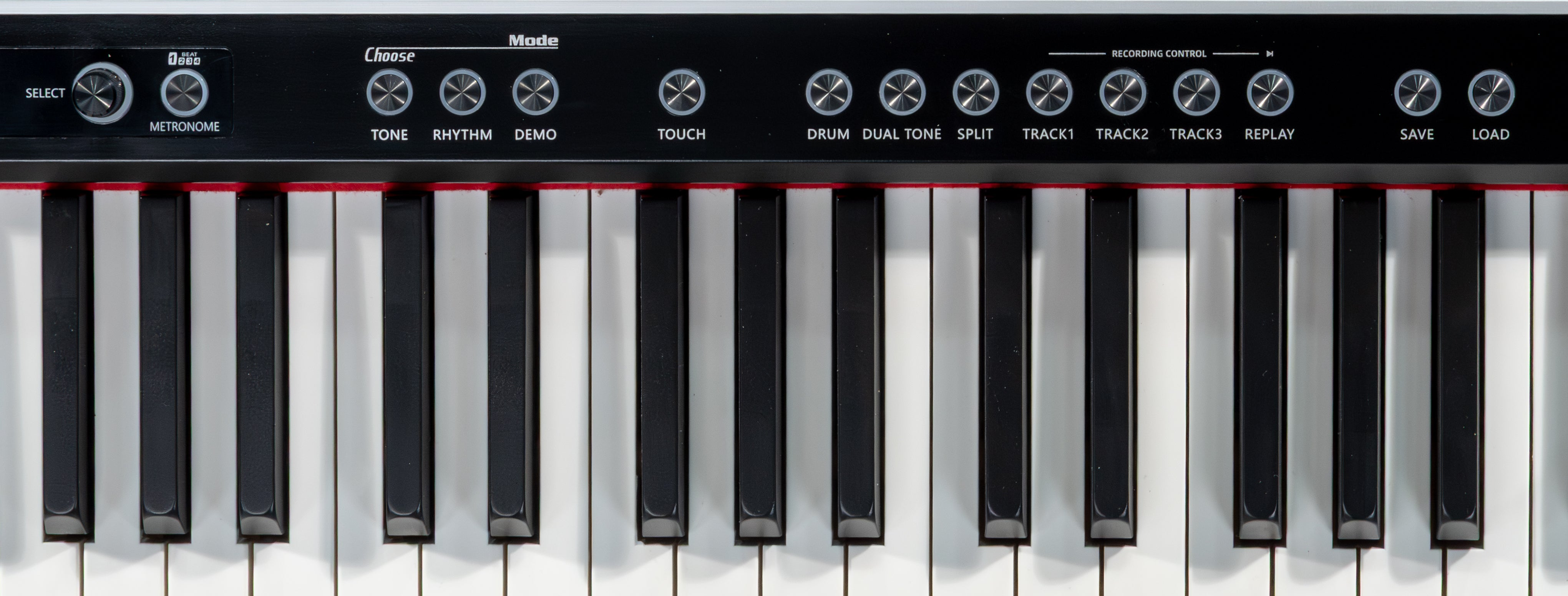 Nahaufnahme einer Digitalpianotastatur mit schwarz-weißen Tasten und Reglern auf dem Bedienfeld.
