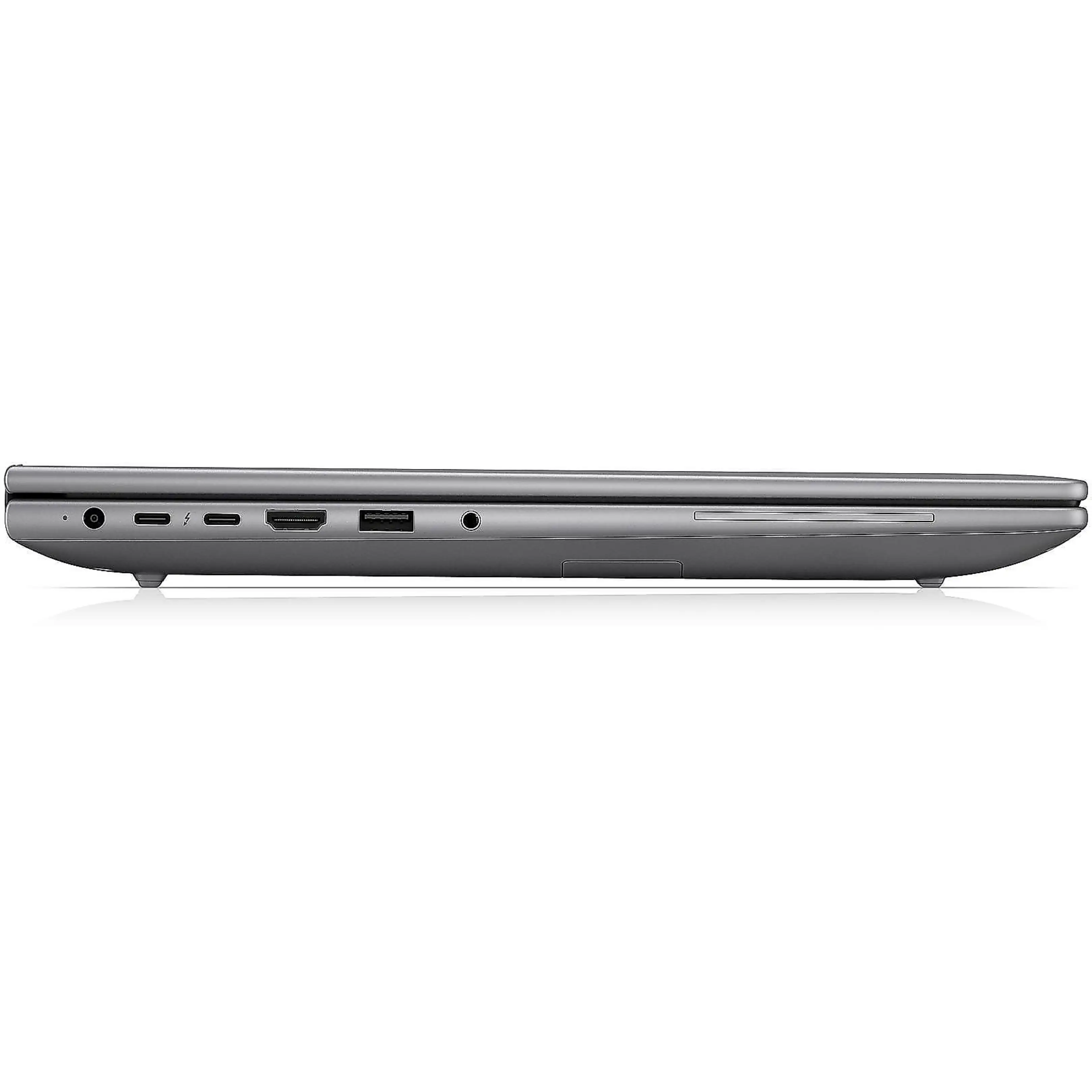 Vista laterale di un laptop grigio chiuso che mostra varie porte sul lato su una superficie riflettente.